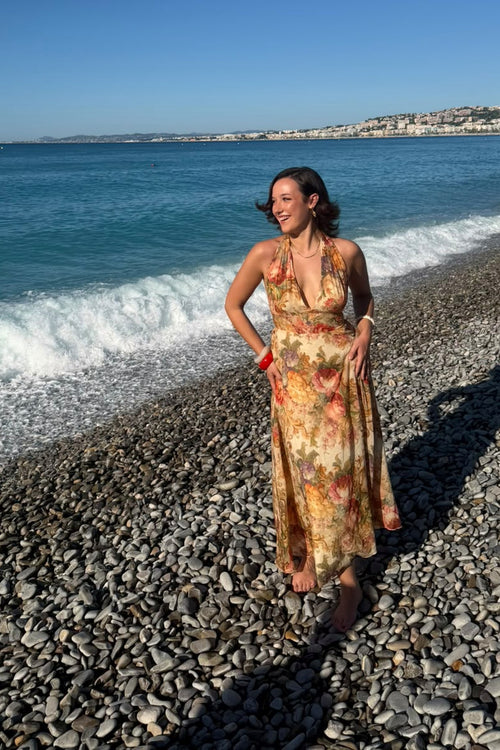 Robe longue MAŸRA Marilyn imprimé floral, décolleté en V et bretelles à nouer, portée sur la plage