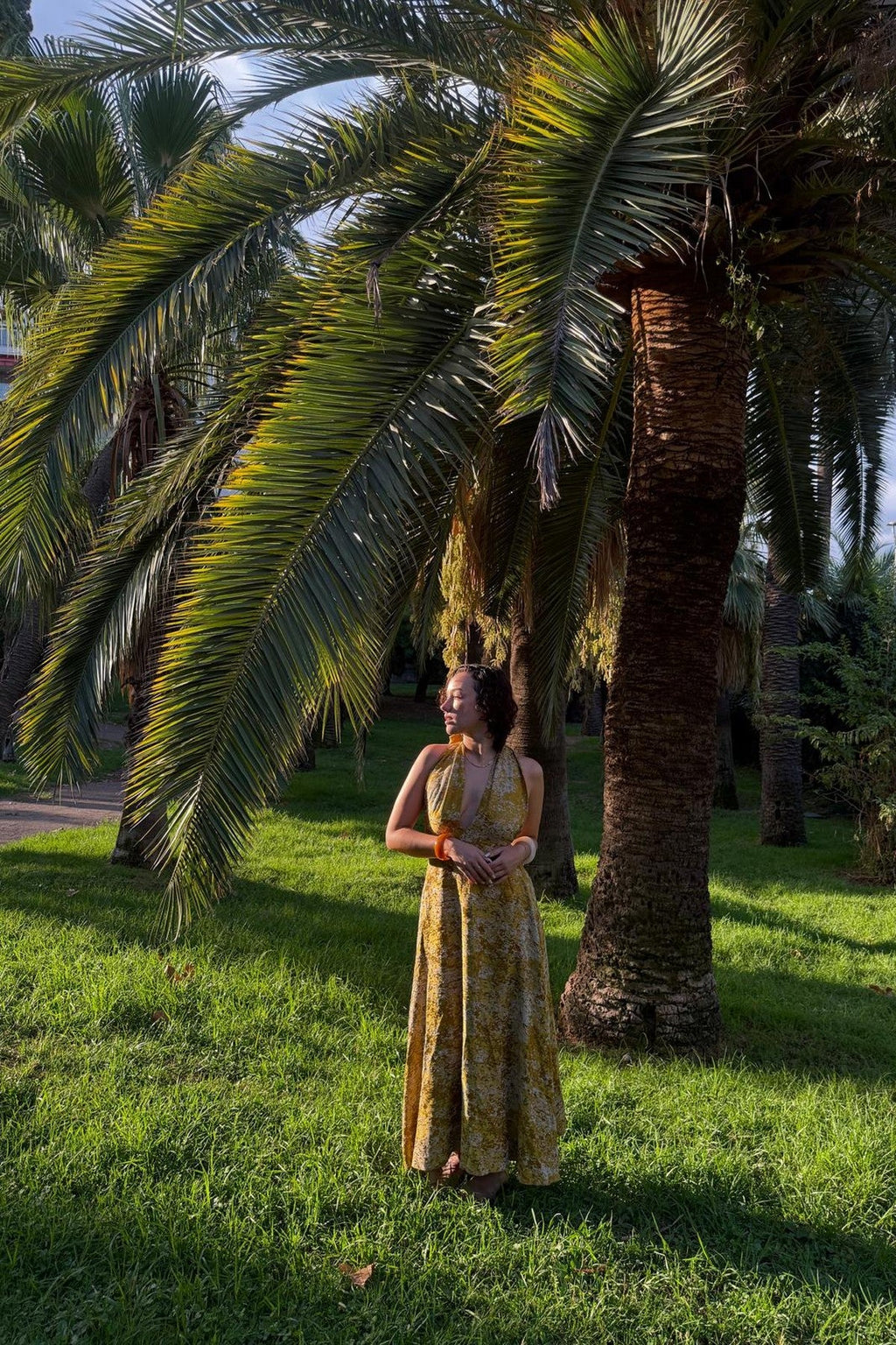 Robe Marilyn Safran MAŸRA portée dans un jardin de palmiers à Nice