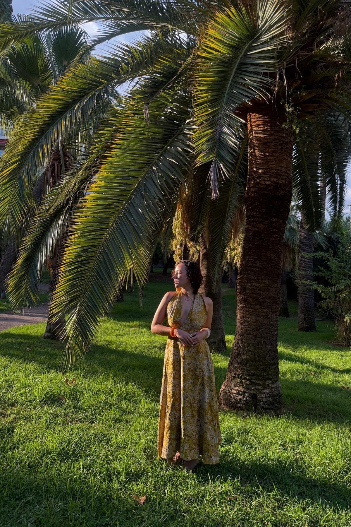 Robe Marilyn Safran MAŸRA portée dans un jardin de palmiers à Nice